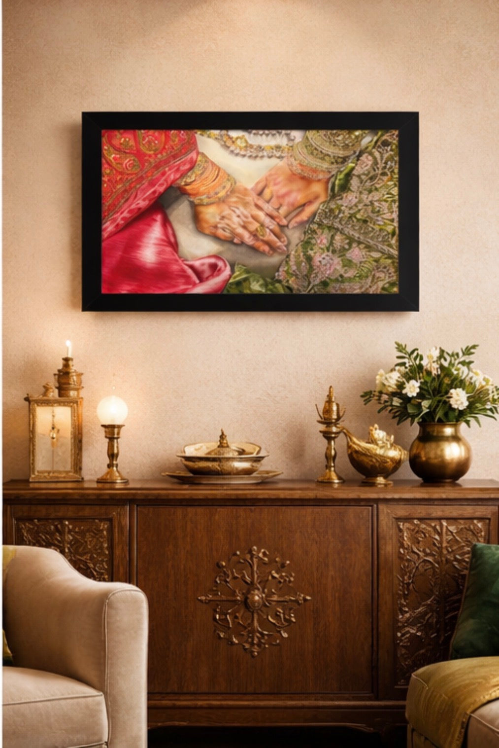 Framed artwork of hands holding a heart above a decorative wooden cabinet with candles and flowers.